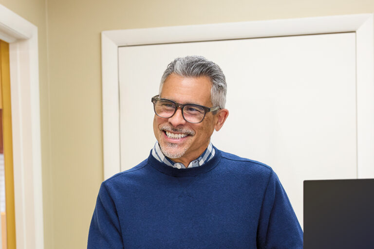 Older man smiling while wearing glasses