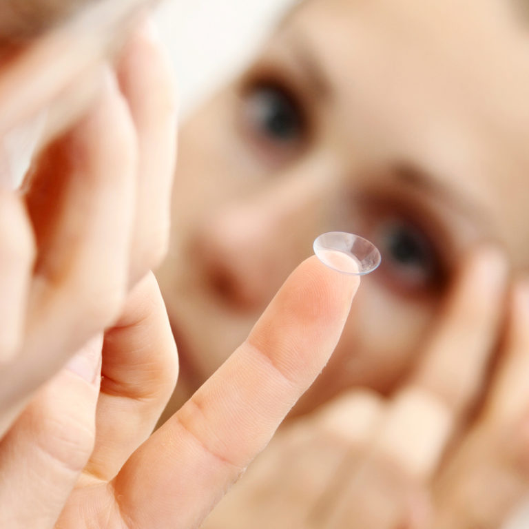Woman putting on a contact lens