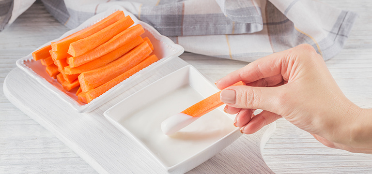 Carrot dipped in ranch dressing